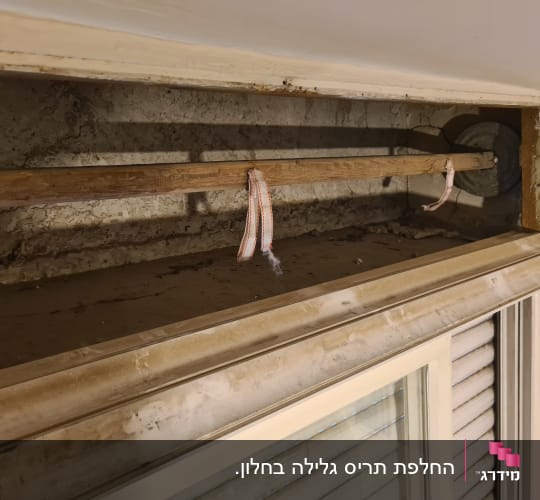 מנגנון תריס ישן עם מוט עץ ורצועות